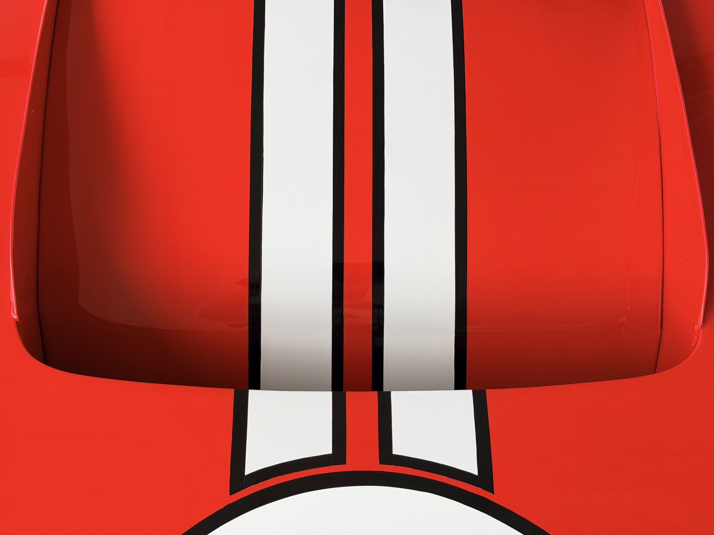 White double racing stripes along the immaculate red of a replica Ford GT40 race car